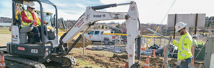 Construction crew using a digger